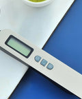 Dettaglio dei pulsanti funzione tara della bilancia cucchiaio digitale Kiwi 300g con display LCD e controlli per tara, unità di misura e accensione